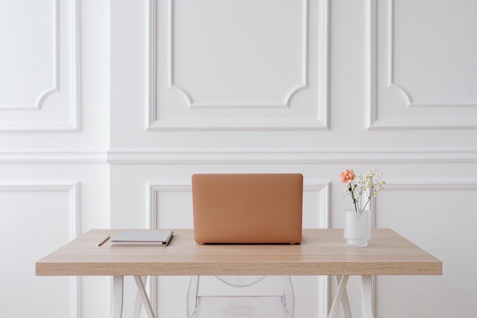 Two people working through paper files and a laptop at an office table.