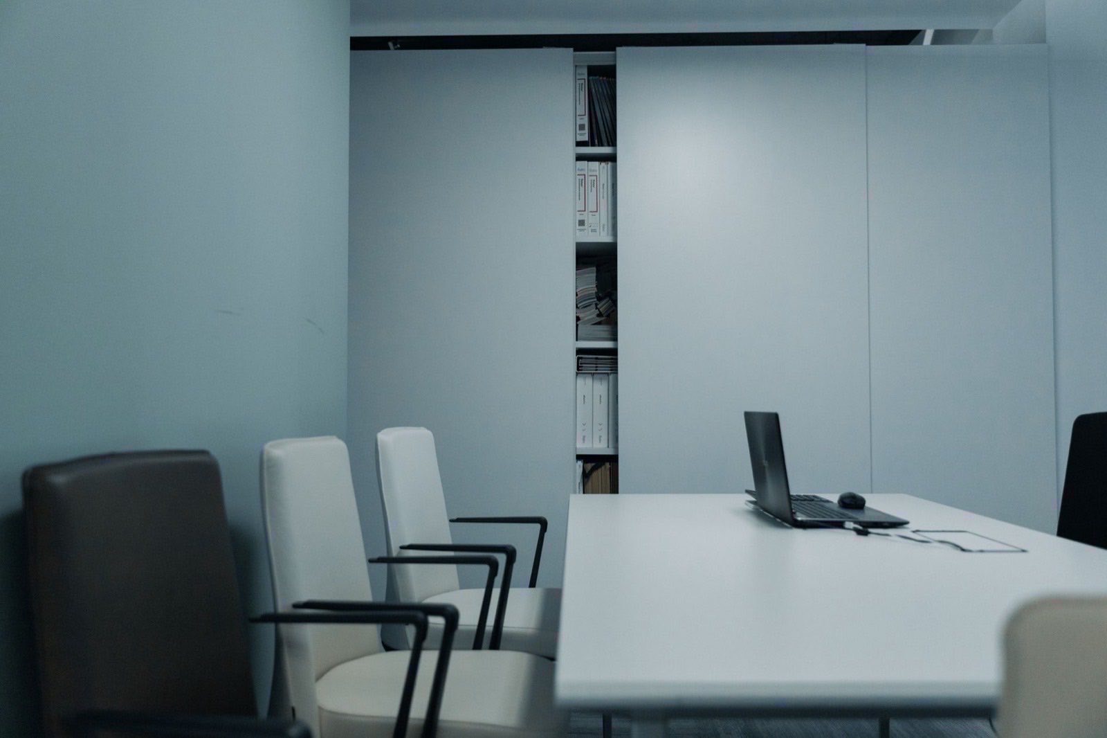 An empty meeting room with a long table, lit by daylight.