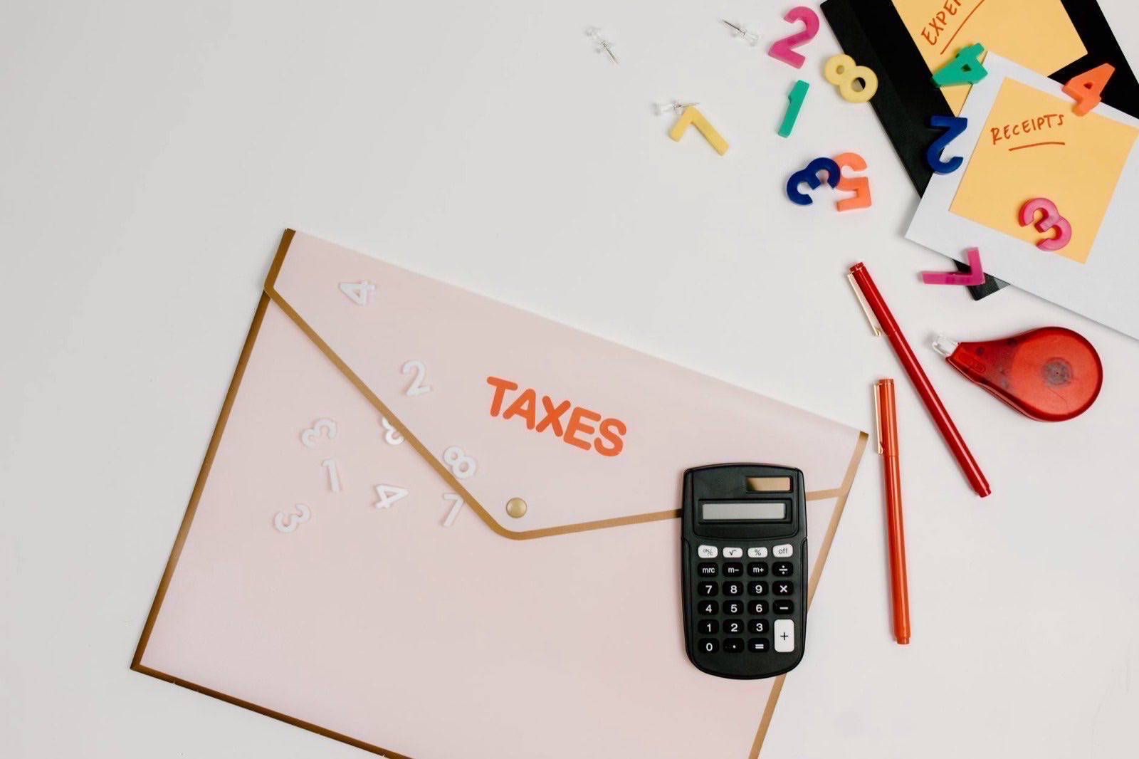 A laptop and a supplier invoice on a desk during a VAT number check.