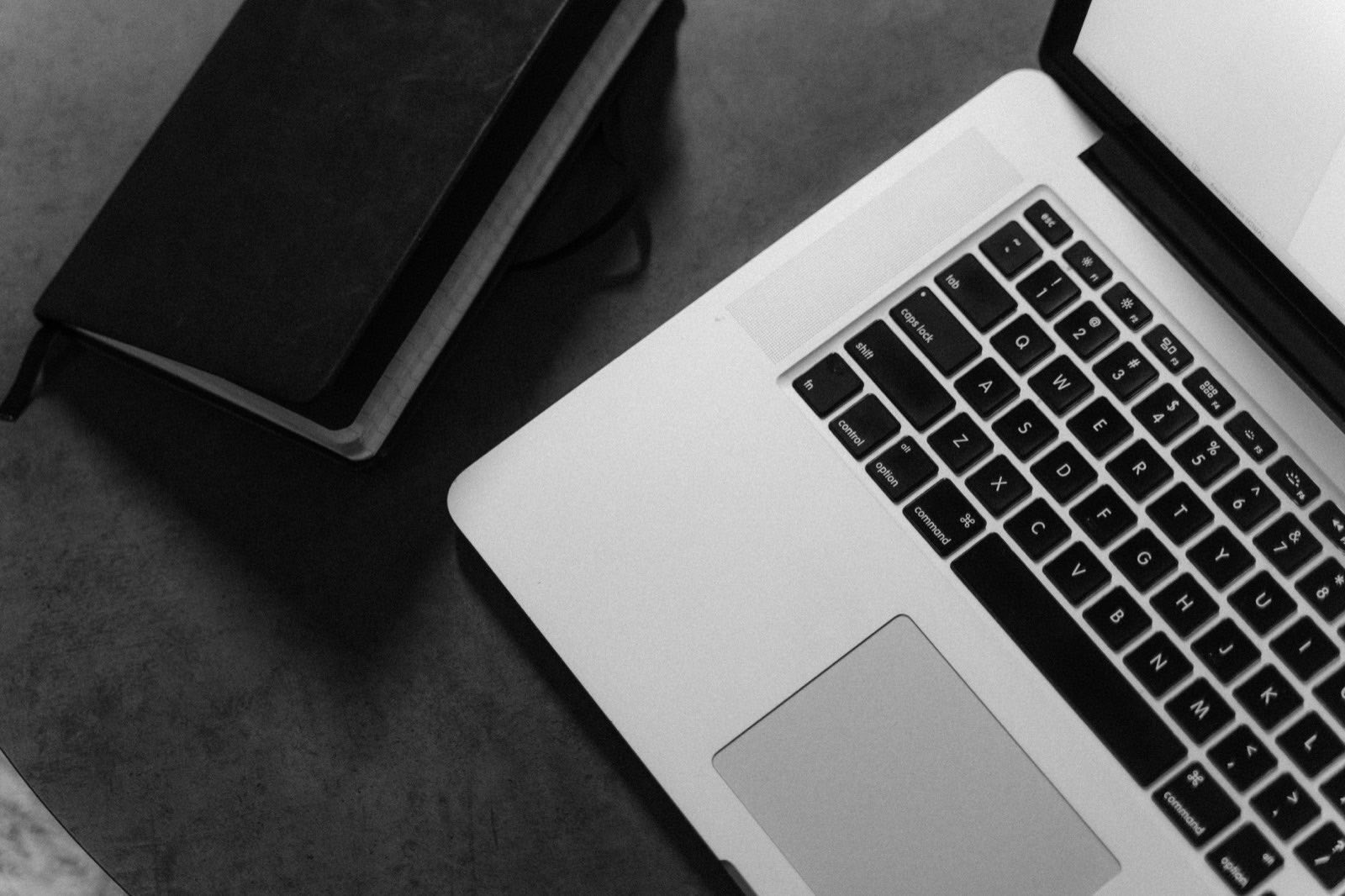 A laptop and a foreign employment contract on a working desk.