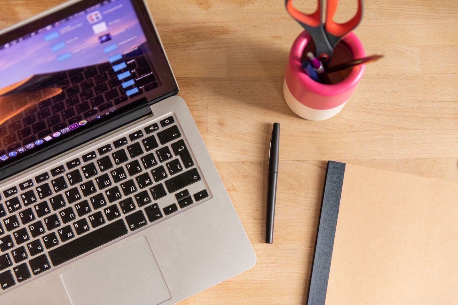 An open ring binder of correspondence on a desk beside a closed laptop.
